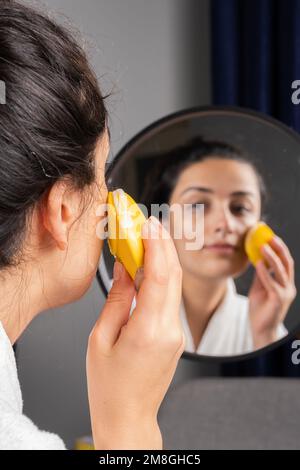 Eine Frau, die Haut putzt, eine weiße braune Millenial-Frau. Mit Schaum und Schwamm. Hautpflege, Beauty Concept Idea Vertikalbild mit Kopierraum. Stockfoto