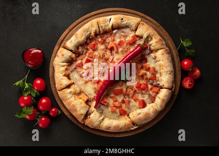 Scharfe indische Pizza auf dunklem Hintergrund von oben Stockfoto