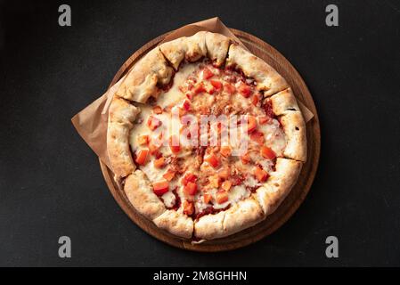 Indische Fladenbrotpizza auf dunklem Hintergrund Stockfoto