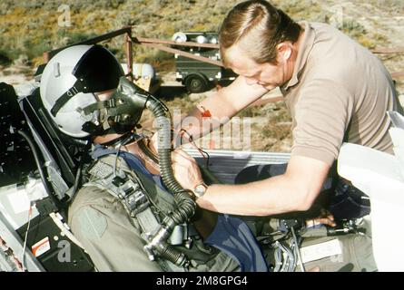 Keith Parson, ein Techniker bei Systems Research Laboratories, Inc., testet Schaltkreise an der Advanced Dynamic Anthropomorphic Manikin (ADAM), einer Kreation, die die neuesten Fortschritte in der Air Force-Technologie repräsentiert, die in Stoß- und Abwurftests eingesetzt wird. ADAM fährt mit einer MASE-Vorrichtung (MASE = raketengetriebener multiaxialer Sitzauswurf), aus der die Prüfpuppe ausgeworfen wird, um Verletzungen von Piloten, die aus dem Flugzeug ausgeworfen werden, vorherzusagen und zu verhindern. Basis: Luftwaffenstützpunkt Holloman Bundesstaat: New Mexico(NM) Land: Vereinigte Staaten von Amerika(USA) Stockfoto