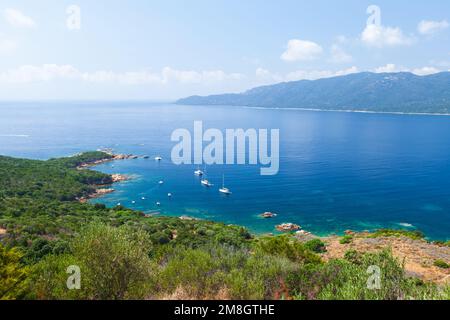 Korsika Insel an einem sonnigen Tag, Kupabia Golf. Sommerlandschaft mit Vergnügungsbooten, die in der Nähe der felsigen Küste vor Anker liegen Stockfoto