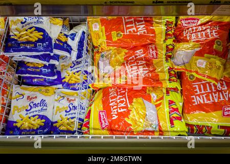 Italien - 12. Januar 2023: Packungen mit gefrorenen vorgekochten pommes frites in Kühltheke zum Verkauf im italienischen Supermarkt Stockfoto