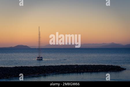 Von der Promenade in der Nähe von Playa Dorada blickt man aufs Meer. In der Nähe der Küste und in der Ferne liegen die Berge von Fuerteventura. Stockfoto