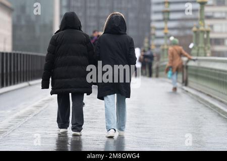 Die Leute laufen im Regen auf der Westminster Bridge, im Zentrum von London. Foto: Samstag, 14. Januar 2023. Stockfoto