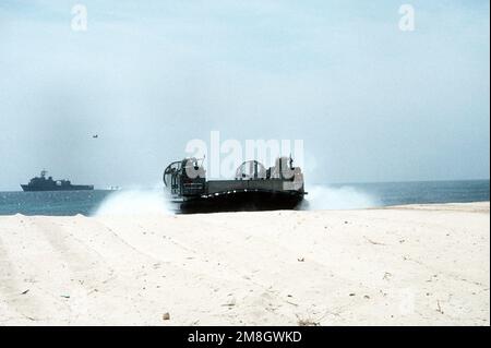 Ein luftgepolstertes Landungsschiff (LCAC) kommt mit Vorräten vom Dock-Landungsschiff USS RUSHMORE (LSD-47) an Land, das im Hintergrund während der Operation Restore Hope Hilfsmaßnahmen durchführt. Operation/Serie: RESTORE HOPE Base: Modadishu Country: Somalia (SOM) Stockfoto