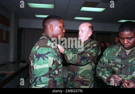 GEN. Gordon R. Sullivan, Stabschef der Armee, bewirbt James C. Woodall von Headquarters and Headquarters Co., 2. Mrd. EUR, 87. Inf. Regt., 10. Mountain Div (Leichte Infanterie), auf den Rang der Private 1. Klasse. GEN. Sullivan besucht Fort Drum, um Soldaten über die Operation Restore Hope zu informieren. Betreff Operation/Serie: RESTORE HOPE Base: Fort Drum Staat: New York (NY) Land: Vereinigte Staaten von Amerika (USA) Stockfoto