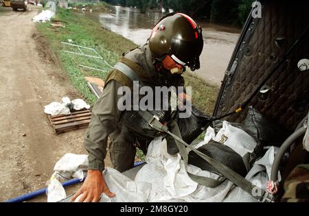 PERSONAL SGT. Fred Miller von der Army National Guard lädt Sandsäcke auf einen UH-1 Helikopter. Der Hubschrauber trägt Sandsäcke zur Kläranlage des Wasserwerks (genaues Datum unbekannt). Basis: Des Moines Staat: Iowa (IA) Land: Vereinigte Staaten von Amerika (USA) Stockfoto
