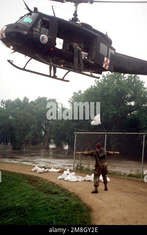 Ein UH-1-Hubschrauber der US Army National Guard entlädt Sandsäcke in der Kläranlage des Wasserwerks zur Verwendung beim Bau einer Mauer, um Hochwasser zurückzuhalten. (Genaues Datum unbekannt). Basis: Des Moines Staat: Iowa (IA) Land: Vereinigte Staaten von Amerika (USA) Stockfoto