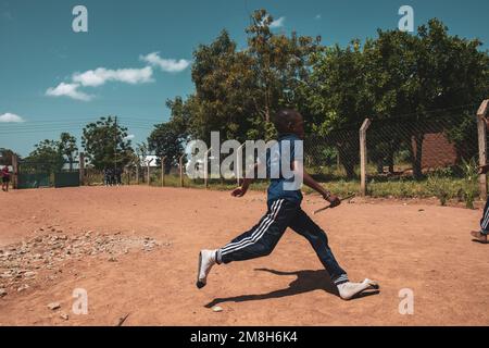 25. März 2022 - Mwanza, Tansania - Kinder, die auf dem Schulgelände spielen und Spaß haben. Laufen, Seil überspringen, Football spielen. Stockfoto