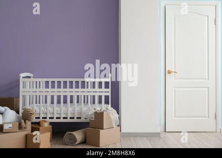 Pappkartons mit Kinderbett im Kinderzimmer am Umzugstag Stockfoto