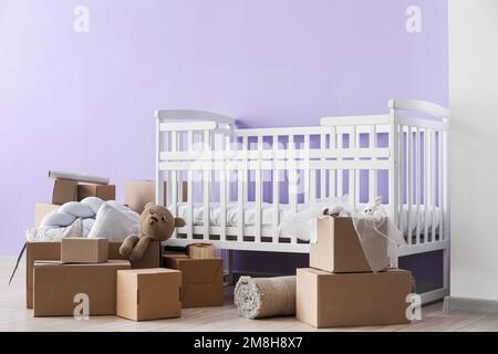 Pappkartons mit Kinderbett im Kinderzimmer am Umzugstag Stockfoto