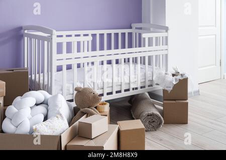 Pappkartons mit Kinderbett im Kinderzimmer am Umzugstag Stockfoto
