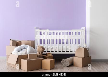 Pappkartons mit Kinderbett im Kinderzimmer am Umzugstag Stockfoto