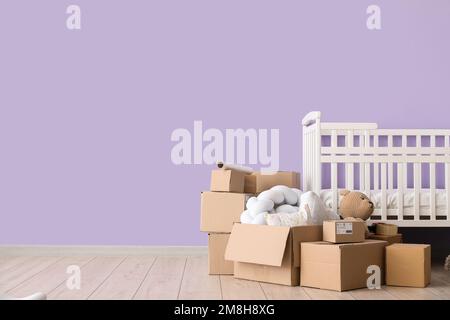 Pappkartons mit Kinderbett im Kinderzimmer am Umzugstag Stockfoto