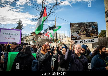 Jerusalem, Israel. 13. Januar 2023. Israelische und palästinensische Demonstranten schwenken palästinensische Flaggen während einer Demonstration im Viertel Scheich Jarrah in Jerusalem. Israelische Polizeibeamte ignorierten, Aktivisten marschierten und schwenkten palästinensische Flaggen entgegen dem Befehl des israelischen Nationalen Sicherheitsministers Itamar Ben Gvir, palästinensische Flaggen von öffentlichen Orten zu entfernen und zu verbieten. Kredit: SOPA Images Limited/Alamy Live News Stockfoto