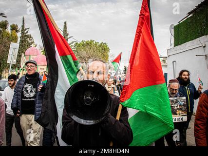 Jerusalem, Israel. 13. Januar 2023. Israelische und palästinensische Demonstranten schwenken palästinensische Flaggen während einer Demonstration im Viertel Scheich Jarrah in Jerusalem. Israelische Polizeibeamte ignorierten, Aktivisten marschierten und schwenkten palästinensische Flaggen entgegen dem Befehl des israelischen Nationalen Sicherheitsministers Itamar Ben Gvir, palästinensische Flaggen von öffentlichen Orten zu entfernen und zu verbieten. Kredit: SOPA Images Limited/Alamy Live News Stockfoto