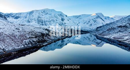 Eine schöne Reflexion der schneebedeckten Berge in Llyn Ogwen a Lake im Snowdonia National Park, North Wales, Großbritannien Stockfoto