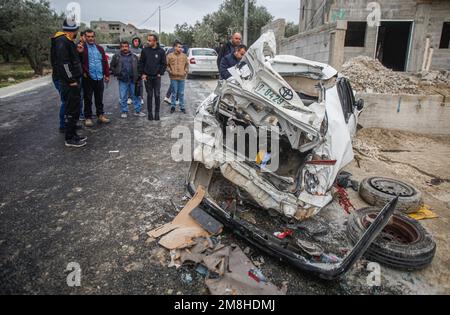 Dschenin, Palästina. 14. Januar 2023. Die Palästinenser inspizieren das Auto, in dem zwei Palästinenser von der israelischen Armee während ihrer Verfolgung getötet wurden, nachdem sie das Feuer auf einen Militärposten in der Stadt Jaba in der Nähe von Dschenin im besetzten Westjordanland eröffnet hatten. Kredit: SOPA Images Limited/Alamy Live News Stockfoto
