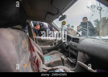 Dschenin, Palästina. 14. Januar 2023. Die Palästinenser inspizieren das Auto, in dem zwei Palästinenser von der israelischen Armee während ihrer Verfolgung getötet wurden, nachdem sie das Feuer auf einen Militärposten in der Stadt Jaba in der Nähe von Dschenin im besetzten Westjordanland eröffnet hatten. Kredit: SOPA Images Limited/Alamy Live News Stockfoto