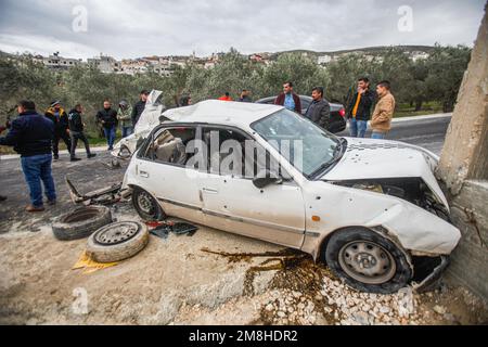 Dschenin, Palästina. 14. Januar 2023. Die Palästinenser inspizieren das Auto, in dem zwei Palästinenser von der israelischen Armee während ihrer Verfolgung getötet wurden, nachdem sie das Feuer auf einen Militärposten in der Stadt Jaba in der Nähe von Dschenin im besetzten Westjordanland eröffnet hatten. Kredit: SOPA Images Limited/Alamy Live News Stockfoto