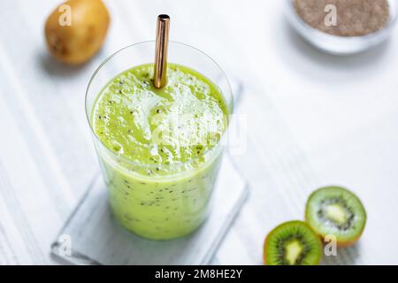 Grüner Smoothie in Glas serviert mit Stroh. Aus Kiwi- und Chiasamen. Super Food und Antioxidans für einen gesunden Lebensstil Stockfoto
