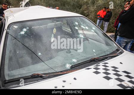 Dschenin, Palästina. 14. Januar 2023. Die Palästinenser inspizieren das Auto, in dem zwei Palästinenser von der israelischen Armee während ihrer Verfolgung getötet wurden, nachdem sie das Feuer auf einen Militärposten in der Stadt Jaba in der Nähe von Dschenin im besetzten Westjordanland eröffnet hatten. (Foto von Nasser Ishtayeh/SOPA Images/Sipa USA) Guthaben: SIPA USA/Alamy Live News Stockfoto