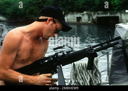 Ein Mitglied der Special Boat Unit 24 (SBU-24) überprüft ein leichtes Maschinengewehr M-60E3 auf einem PB Mark III Patrouillenboot während der gemeinsamen Serviceübung Ocean Venture '93. Mitglieder der SBU-24 agieren während der Übung als Drogenschmuggler. Betrifft Operation/Serie: OCEAN VENTURE '93 Bundesstaat: Puerto Rico (PR) Land: Vereinigte Staaten von Amerika (USA) Stockfoto
