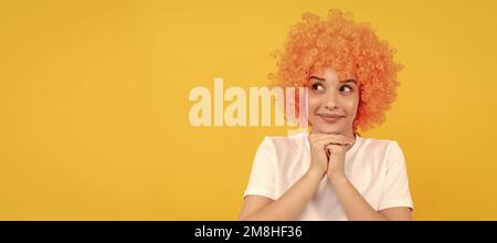 Verträumte freaky Frau in lockigen Clown Perücke für Party, träumen. Frau isoliert Gesicht Porträt, Banner mit Kopieplatz. Stockfoto