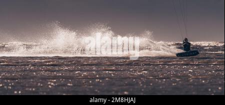 Ein Kiteboarder, der von einem Power Drachen über das Wasser gezogen wurde. New Brighton, Merseyside, England. Stockfoto