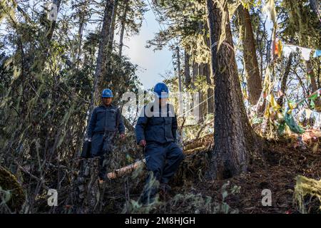 (230114) -- DEQEN, 14. Januar 2023 (Xinhua) -- Wangden (L) und sein Kollege Zhang Jincheng inspizieren Stromübertragungsleitungen auf einem Berg in Deqen County, Provinz Yunnan im Südwesten Chinas, 9. Januar 2023. Wangden, 34, ist stellvertretender Direktor der Yunnan-Zweigstelle des Stromversorgungswerks Yanmen von China Southern Power Grid im Deqen County. 2015 wurde er beauftragt, Wartungsarbeiten in Yubeng zu übernehmen, einem Dorf am Fuße der schneebedeckten Berge. Als Yubengs dienstältester Energieversorger hat der Mann gewaltige Veränderungen im Dorf erlebt. In der Vergangenheit, Yubeng Stockfoto