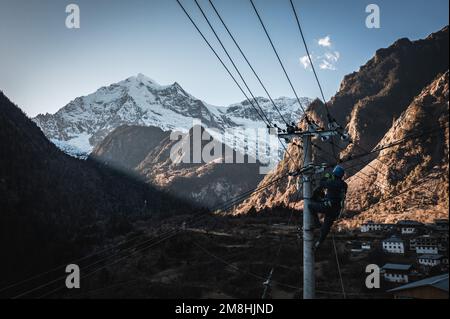 (230114) -- DEQEN, 14. Januar 2023 (Xinhua) -- Dieses Luftfoto wurde am 9. Januar 2023 aufgenommen und zeigt Wangden bei der Inspektion von Stromübertragungsleitungen im Dorf Yubeng im Deqen County, südwestlich Chinas Provinz Yunnan. Wangden, 34, ist stellvertretender Direktor der Yunnan-Zweigstelle des Stromversorgungswerks Yanmen von China Southern Power Grid im Deqen County. 2015 wurde er beauftragt, Wartungsarbeiten in Yubeng zu übernehmen, einem Dorf am Fuße der schneebedeckten Berge. Als Yubengs dienstältester Energieversorger hat der Mann gewaltige Veränderungen im Dorf erlebt. In der Vergangenheit, Yube Stockfoto