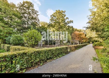 Der Park mit vielen Bäumen, Büschen und Pflanzen auf beiden Seiten der Straße gibt es einen Pfad, der hinauf zum führt Stockfoto