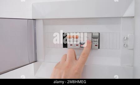 Einschalten des Leistungsschalters an der Bedienkonsole, nachdem er aufgrund von Überlastung ausgelöst wurde Stockfoto