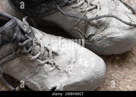 Schuhe stark mit grauer Farbe auf einer Asphaltnaht verfärbt Stockfoto