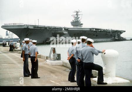 Vom Pier aus beobachten Seeleute, wie der große Hafen DAHLONEGA (YTB-770), MARINETTE (YTB-791) und OKMULGEE (YTB-765) nach seiner Ankunft nach einem sechsmonatigen Einsatz im Mittelmeer mit dem nuklearen Flugzeugträger USS THEODORE ROOSEVELT (CVN-71) in den Hafen zieht. Basis: Marine Air Station, Norfolk Bundesstaat: Virginia (VA) Land: Vereinigte Staaten von Amerika (USA) Stockfoto