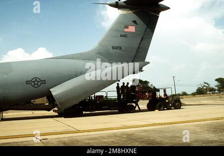 Linke Rückansicht des Heckabschnitts eines C-141B-Starlifter-Flugzeugs. Marinepersonal lädt Marineausrüstung herunter. Das Flugzeug brachte die ersten Marines (33) nach Guantanamo Bay, um die jüngsten Probleme in Haiti zu unterstützen. Basis: Guantanamo Bay Country: Kuba (CUB) Stockfoto