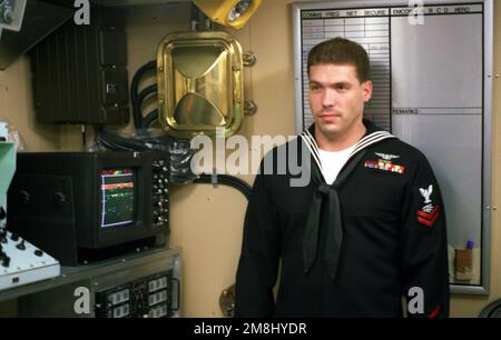 Radioman 2. Klasse Steven Tate erläutert den Betrieb der Ausrüstung der Kampfinformationszentren an Bord des Küstenpatrouillenschiffs USS TEMPEST (PC-2), während das Schiff für öffentliche Touren am Washington Navy Yard geöffnet ist. Rechts von Tate befindet sich der Monitor für das Westmarer Tiefendetektor-Side-Scan-Sonar. Basis: Washington State: District of Columbia (DC) Land: Vereinigte Staaten von Amerika (USA) Stockfoto