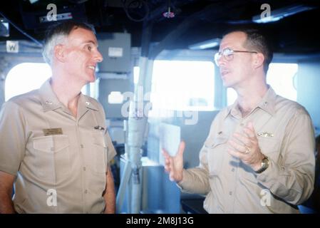 Konteradmiral Harold W. Gehman, Jr., Commander Cruiser Destroyer Group Acht und derzeit Commander Joint Task Force 120, spricht mit dem kommandierenden Offizier des Raketenkreuzers USS YORKTOWN (CG-48) der Ticonderoga-Klasse, Captain Michael G. Mullen, während sich das Schiff Guantanamo Bay, Kuba, nähert. Die YORKTOWN macht eine Dienstreise vor der Küste von Haiti, als Teil der Operation Support Democracy. Betrifft Operation/Serie: UNTERSTÜTZUNG DER DEMOKRATIE Land: Karibik Stockfoto