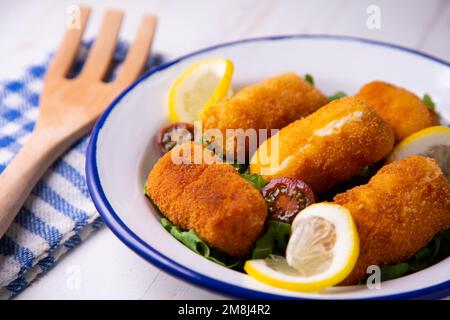 Fischkroketten. Die Krokette ist eine Portion Teig, der aus einer dichten Sauce wie Becamel und einem Hackfleisch aus verschiedenen Zutaten oder Gemüse hergestellt wird. Stockfoto