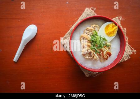 Congee Porridge mit Hühnerscheibe, Tofu, Ei, Congee Porridge aus hongkong. chinesisches Essen Stockfoto