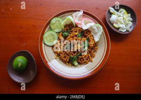 mie Tek Tek oder gebratene Nudeln mit Eiernudeln mit Hühnchen, Kohl, Senfgrün, Fleischbällchen, Rührei. indonesisches Essen Stockfoto