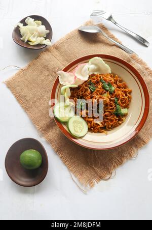 mie Tek Tek oder gebratene Nudeln mit Eiernudeln mit Hühnchen, Kohl, Senfgrün, Fleischbällchen, Rührei. indonesisches Essen Stockfoto