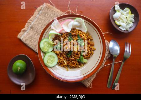 mie Tek Tek oder gebratene Nudeln mit Eiernudeln mit Hühnchen, Kohl, Senfgrün, Fleischbällchen, Rührei. indonesisches Essen Stockfoto