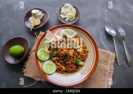 mie Tek Tek oder gebratene Nudeln mit Eiernudeln mit Hühnchen, Kohl, Senfgrün, Fleischbällchen, Rührei. indonesisches Essen Stockfoto