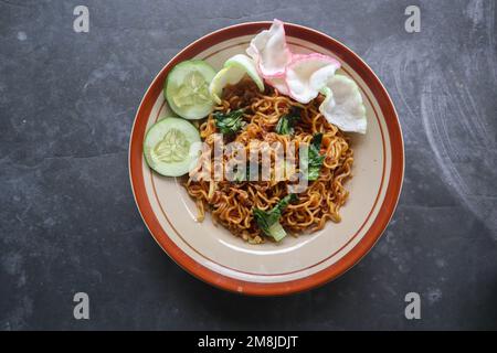 mie Tek Tek oder gebratene Nudeln mit Eiernudeln mit Hühnchen, Kohl, Senfgrün, Fleischbällchen, Rührei. indonesisches Essen Stockfoto