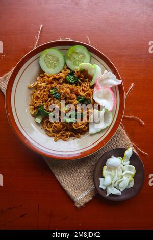 mie Tek Tek oder gebratene Nudeln mit Eiernudeln mit Hühnchen, Kohl, Senfgrün, Fleischbällchen, Rührei. indonesisches Essen Stockfoto