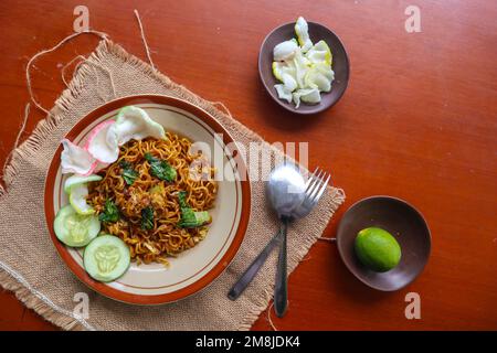 mie Tek Tek oder gebratene Nudeln mit Eiernudeln mit Hühnchen, Kohl, Senfgrün, Fleischbällchen, Rührei. indonesisches Essen Stockfoto