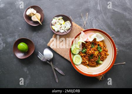 mie Tek Tek oder gebratene Nudeln mit Eiernudeln mit Hühnchen, Kohl, Senfgrün, Fleischbällchen, Rührei. indonesisches Essen Stockfoto