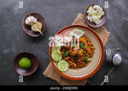 mie Tek Tek oder gebratene Nudeln mit Eiernudeln mit Hühnchen, Kohl, Senfgrün, Fleischbällchen, Rührei. indonesisches Essen Stockfoto