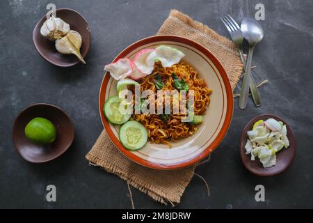 mie Tek Tek oder gebratene Nudeln mit Eiernudeln mit Hühnchen, Kohl, Senfgrün, Fleischbällchen, Rührei. indonesisches Essen Stockfoto